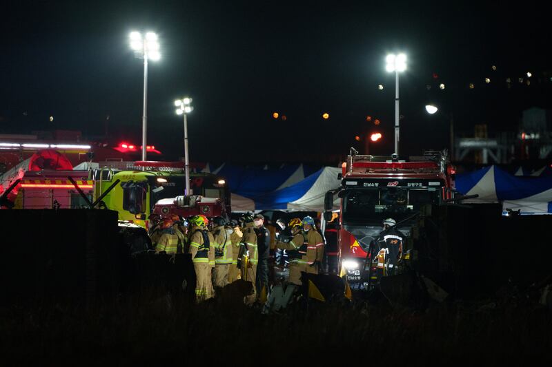 Firefighters and investigators at the scene of the Jeju Air passenger jet crash at Muan International Airport, South Korea, on Sunday night. Photograph: Chang W Lee/New York Times