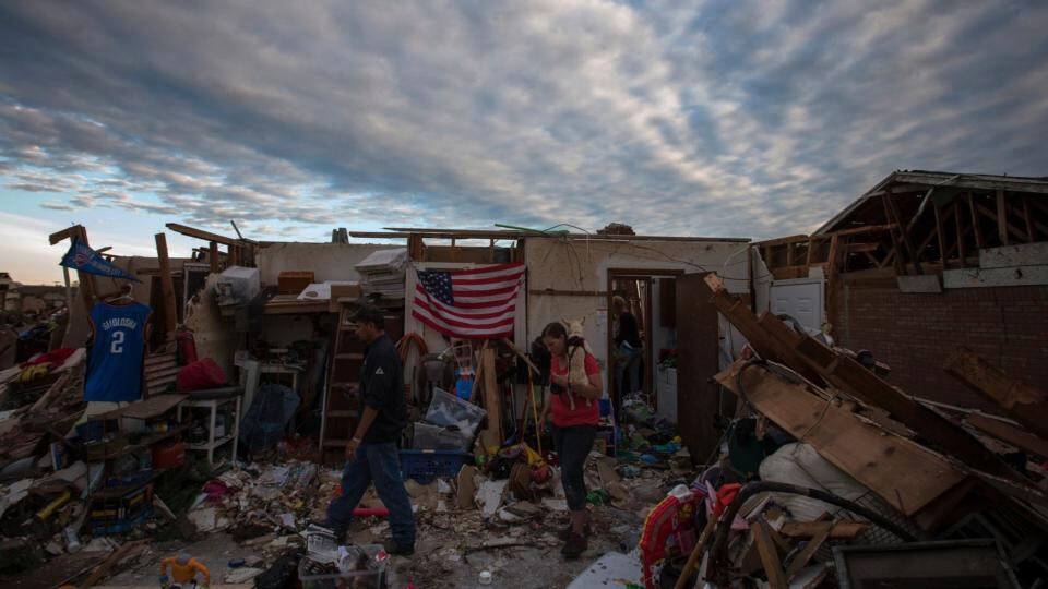 Residents walk through debris of homes. Officials said one factor behind the surprisingly low death toll was the early warning, with meteorologists saying days in advance that a storm system was forming. Photograph: Adrees Latif/Reuters