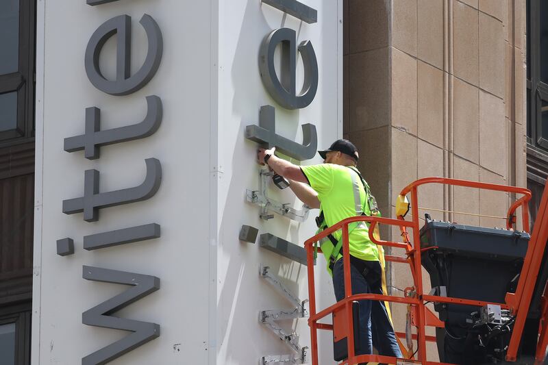 A worker removes letters from the Twitter sign posted on the exterior of Twitter headquarters this week. CEO Elon Musk has rebranded Twitter as "X" and changed its iconic bird logo. Photograph: Justin Sullivan/Getty Images