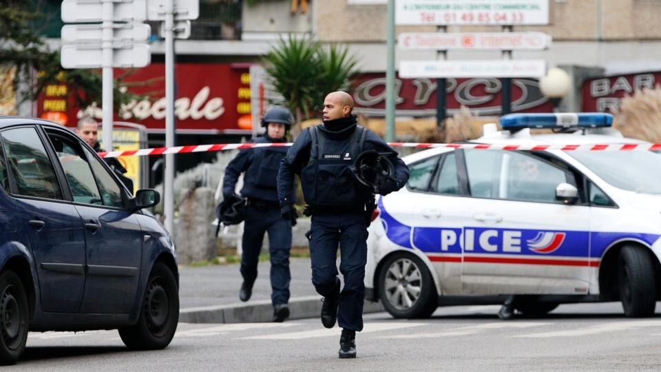 Two police officers run during a police operation inear Paris, France today following a shooting in Montrouge. Photograph: Yoan Valat/EPA