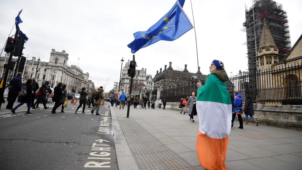 An anti-Brexit protester draped in an Tricolour and holding an EU flag stands outside of the houses of parliament in London on Wednesday. Photograph: Toby Melville/Reuters