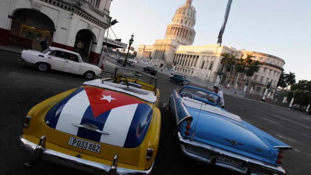 A car with a Cuban flag parked near the Cuban Capitol in Havana. The Cuban revolution has survived through a combination of welfare provision and selective repression as the equal distribution of scarce resources meets the iron fist of state power. Photograph: Enrique De La Osa/Reuters