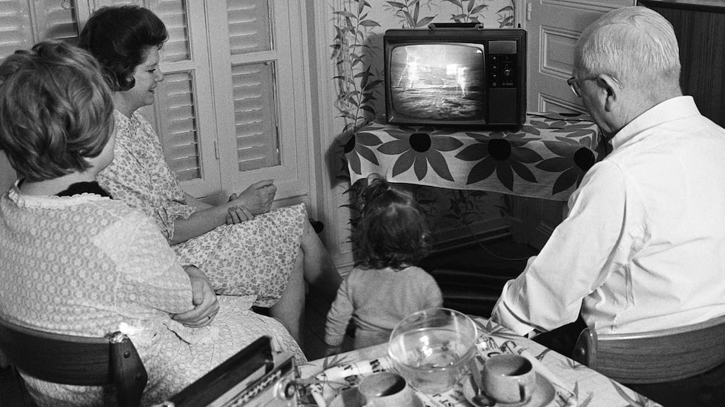 A family watches as US astronaut Neil Armstrong sets his foot on the moon July 20th, 1969. Photograph:  STR / AFP/Getty Images