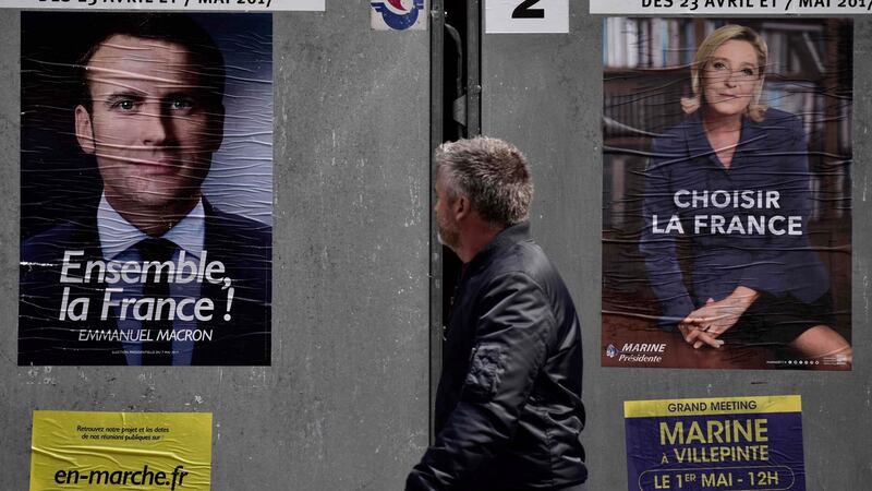A pedestrian walks past posters of French presidential election candidate for the En Marche! movement Emmanuel Macron and far-right candidate Marine Le Pen, in Paris. Photograph: Philippe Lopez/AFP/Getty Images