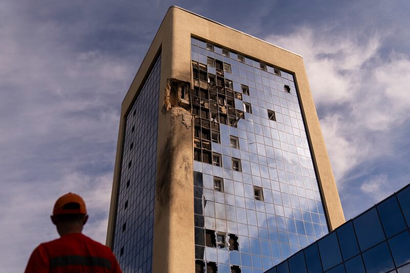 A maintenance worker stands outside a damaged government building in Kyiv after Russian drone strikes continued throughout the night. Photograph: Jae C Hong/AP