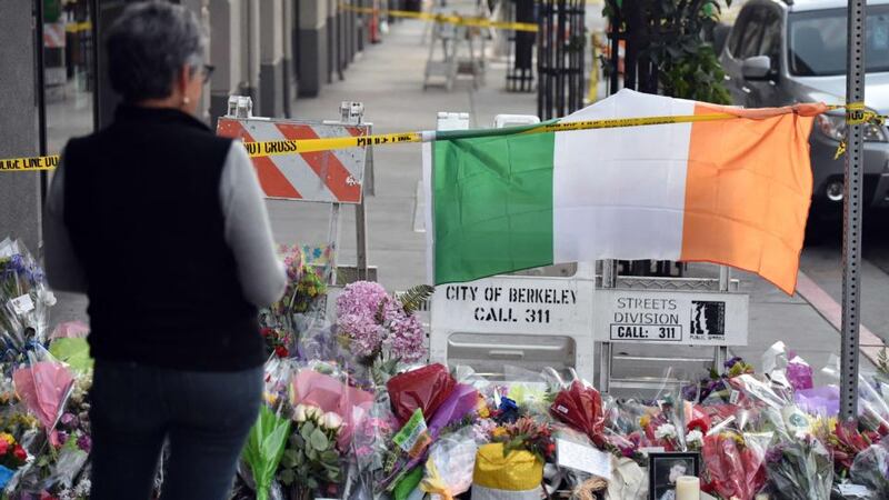 A woman views a memorial for the six Irish students who lost their lives after a balcony gave way in Berkeley, California. The balcony builder may face charges   if investigators find shoddy workmanship caused the  collapse.  Photograph: Josh Edelson/AFP/Getty Images