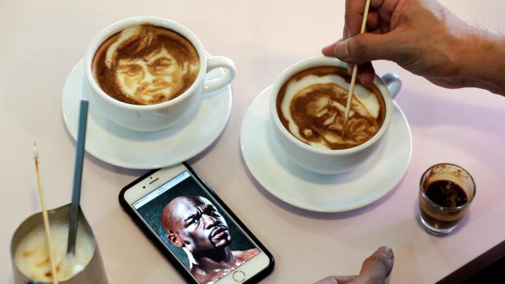 Filipino graphic artist and barista Zach Yonzon, draws the faces of Manny Pacquiao and Floyd Mayweather on two lattes in a coffee shop in Manila, Philippines. Photo: Ritchie B Tongo/EPA