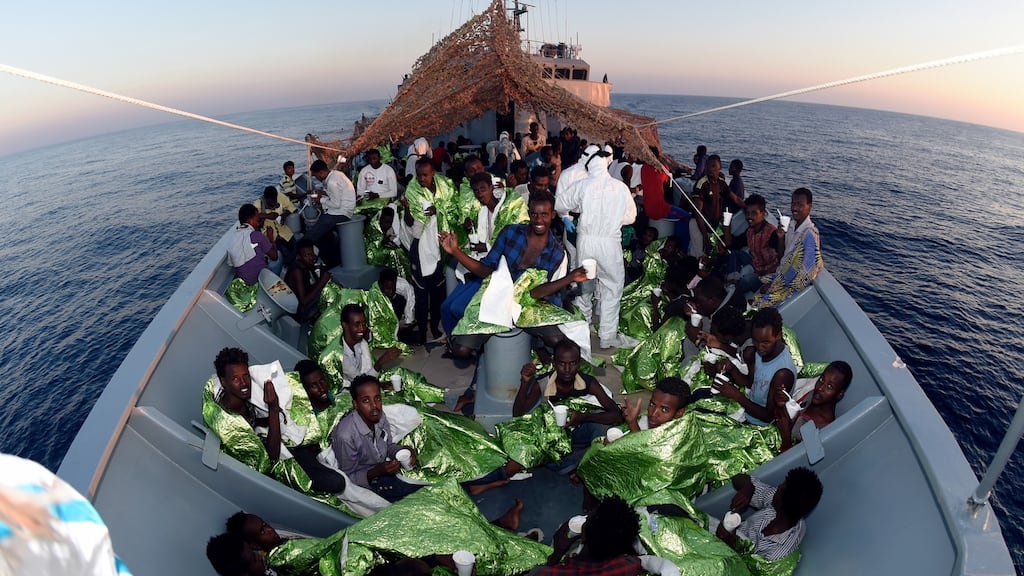 Migrants in thermal blankets enjoy a meal  after being rescued, sitting in  the bow of the LÉ Roisin, in June 2016. File photograph: Able Seaman David Jones/Defence Forces