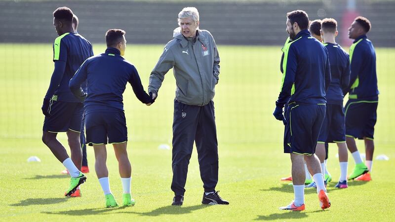 Arsene Wenger and Alexis Sanchez shake hands at a training session on Monday. Photo: Glyn Kirk/Getty Images