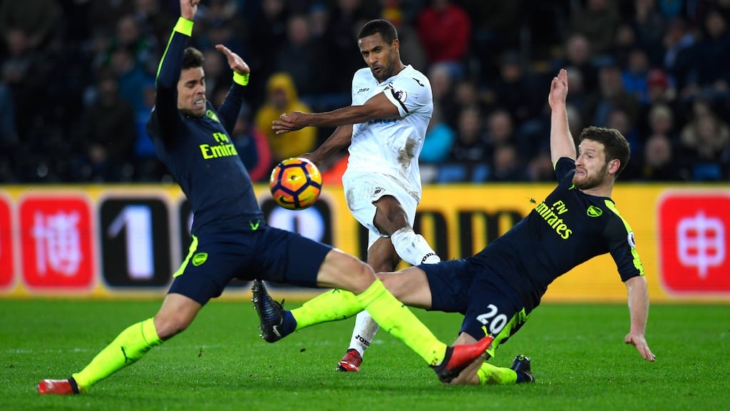 Wayne Routledge of Swansea City shoots, while Gabriel and Shkodran Mustafi of Arsenal attempt to block during their Premier League clash at Liberty Stadium. Photo: Stu Forster/Getty Images