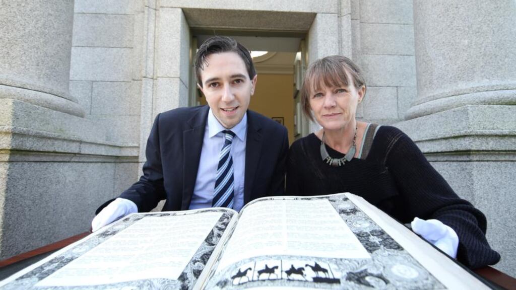 Minister of State with special responsibility for the Office of Public Works Simon Harris viewing the restored memorial books at the War Memorial Gardens, Islandbridge, yesterday, with Sarah McCartan, paper conservator, Marsh’s Library.