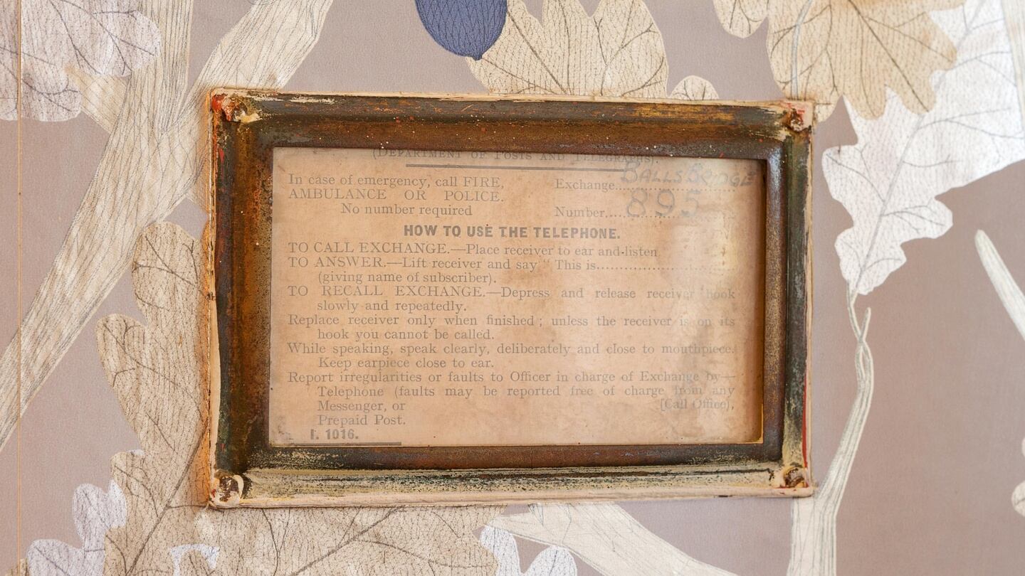 A small glass box on the wall inside the door contains instructions for using the telephone, which was one of the first in the area.