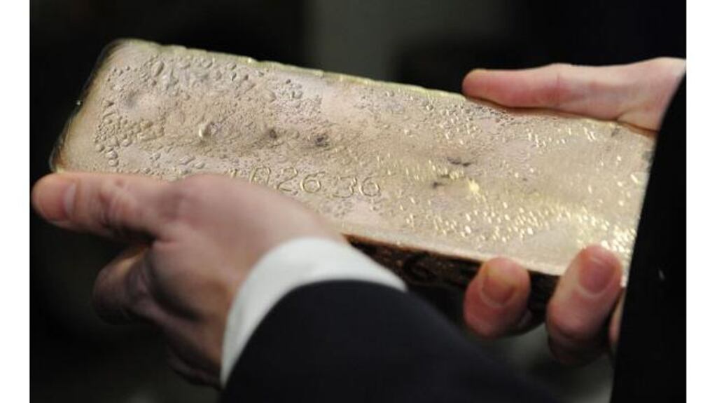 British chancellor of the exchequer George Osbourne holds a gold bar ready for melting at the Birmingham Assay Office yesterday. Last night the UK lost its top AAA rating. Photograph: PA