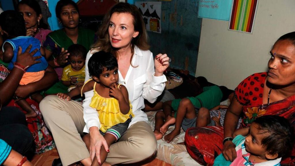 France’s former first lady, Valerie Trierweiler, sits a child in her lap as she talks to health workers and children during a visit to the Ekta Nagar slums in the Mandala area of Mumbai. Photograph: Indranil Mukherjee/Reuters