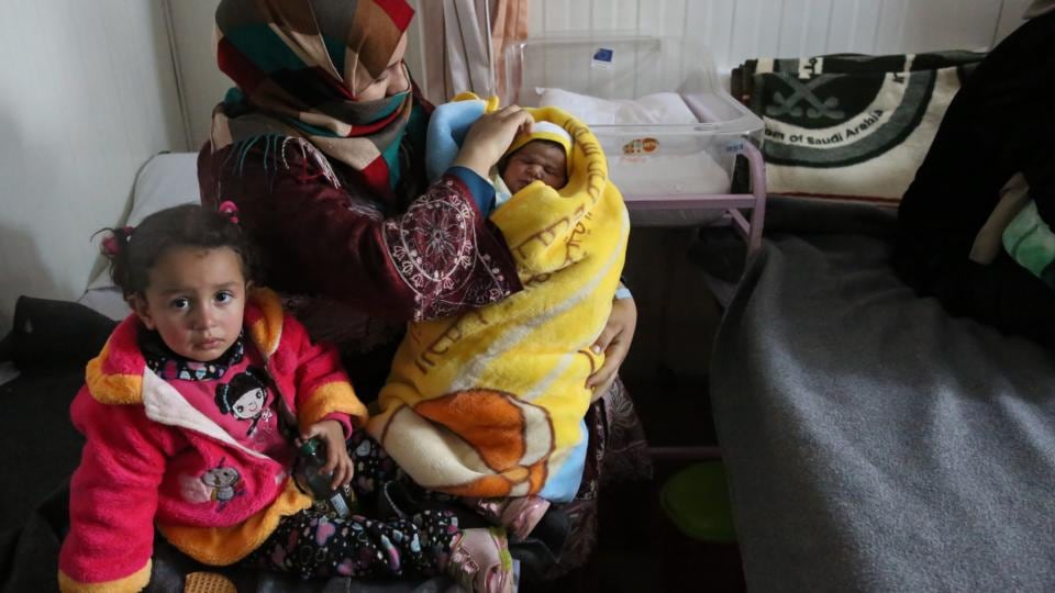 A woman sits with her child and newborn baby in the UN field hospital in Zaatari refugee camp, Jordan. About 170 babies are delivered there each month. Photograph: Sally Hayden