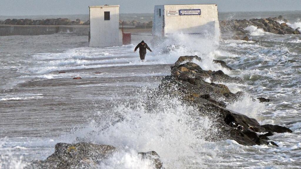 A solitary figure battling with high wind and waves on the Great South Wall at Poolbeg, Dublin, shortly before Christmas. FBD has lowered its full-year earnings expectations as a result of the adverse weather that hit Ireland between December 19th and 31st. Photograph: Eric Luke