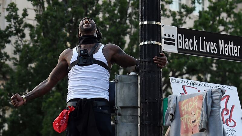 Mike D’angelo screams near a street sign that has been renamed ‘Black Lives Matter Plaza’ near the White House. Photograph: OLIVIER DOULIERY/AFP via Getty Images
