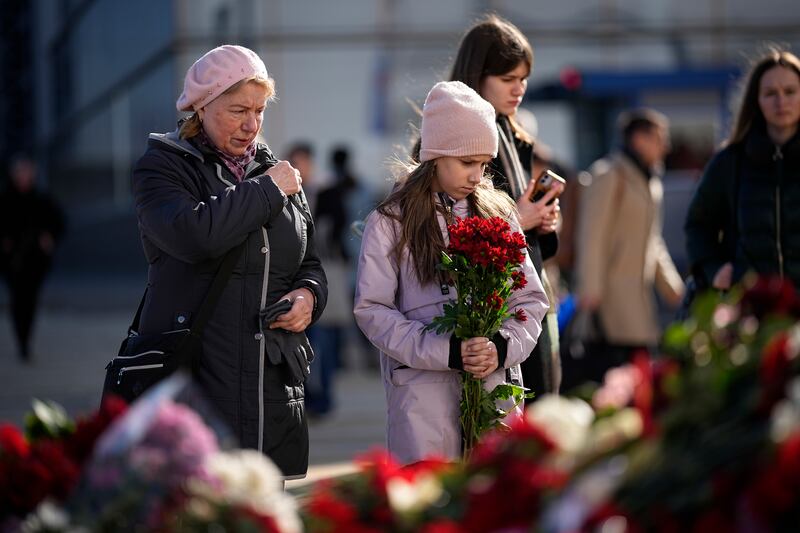 People stand at a makeshift memorial in front of Crocus City Hall, the site of a massace last weekend, on the western outskirts of Moscow on Wednesday. Photograph: Alexander Zemlianichenko/AP