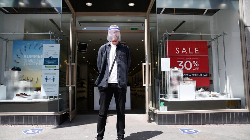 Clarks employee  Jamie Stewards welcomes people into the retailer’s  Grafton Street store in Dublin on Monday.  Photograph: Leon Farrell/Photocall Ireland.