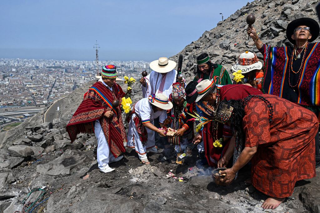 Peruvian shamans take part in a ritual to deliver predictions for the upcoming Earth Day, on top of the San Cristobal hill in Lima, on April 21, 2023. - Several Peruvian shamans equipped with coca leaves, swords, smoking ceramic pots, incense and a live snake took part in the ceremoy. (Photo by Ernesto BENAVIDES / AFP) (Photo by ERNESTO BENAVIDES/AFP via Getty Images)