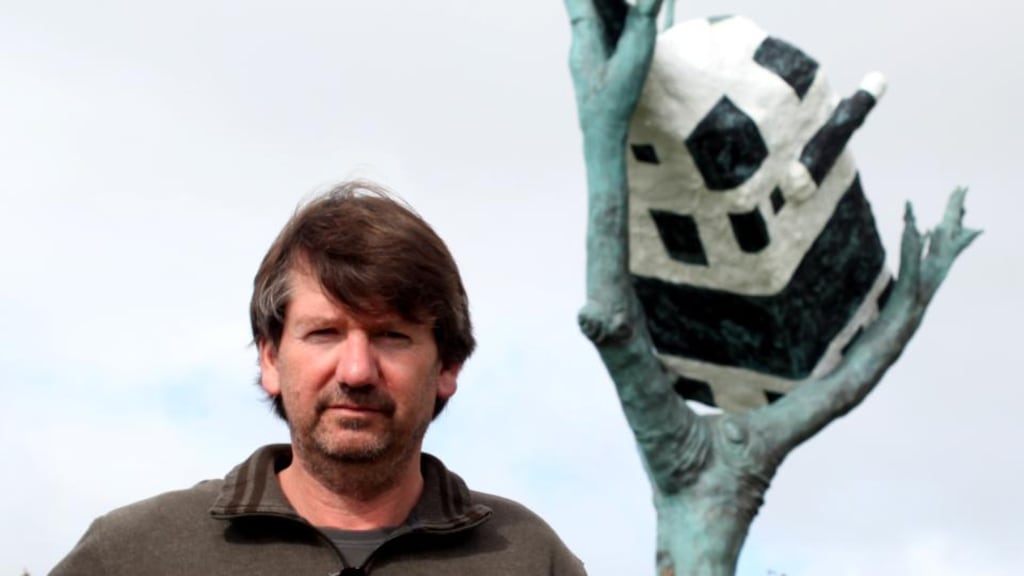 Artist John Kelly with a piece from one of his Cow Up a Tree series