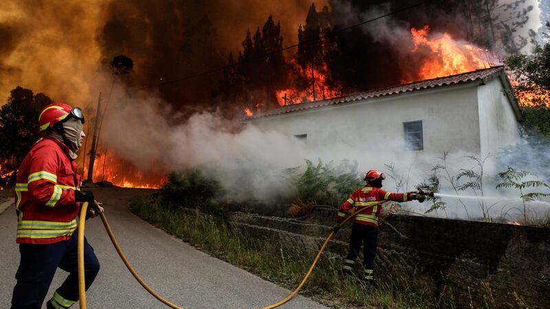 Firefighters battle with a fire. At least 61 people have been killed in forest fires in central Portugal. Photograph: EPA/Paulo Cunha