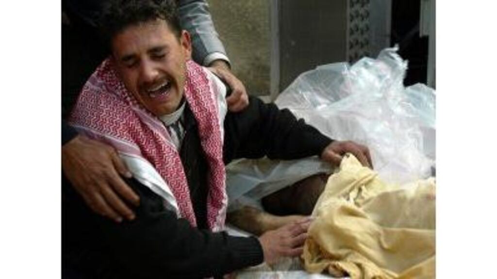 Wisam Najih identifies the body of his dead brother Muhammad outside a morgue at a local hospital.