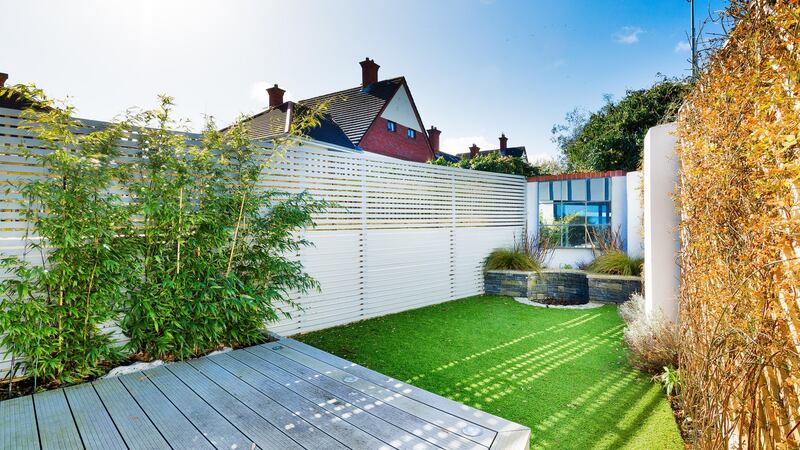 The small, triangular-shaped rear garden is landscaped, with new fencing, and is covered with Astroturf