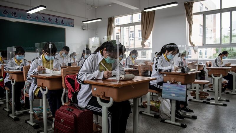 High school students study with plastic partitions in a classroom in Wuhan, with 121 schools reopening in province on Wednesday. Photograph: STR/AFP/Gtty