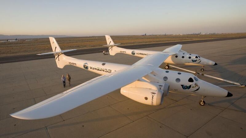 Virgin Group's founder Richard Branson and Burt Rutan, president of Scaled Composites, walk near Virgin Galactic's mothership White Knight in Mojave, California