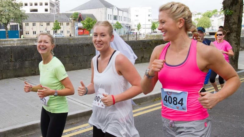 Claire O’Mahony and Hannah Yardy running with Sinead Dollery, who got married on Saturday, competing in the Cork City Marathon today. Photograph: Darragh Kane