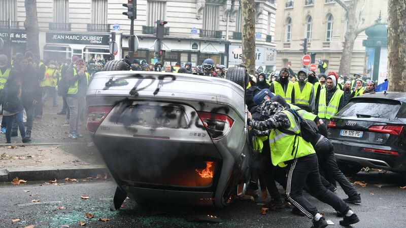Demonstrators destroy a car during a protest of yellow vests against rising oil prices  in Paris: Photograph: Getty