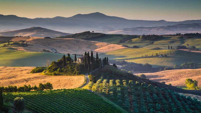 Scenic Tuscany landscape with rolling hills and valleys in golden morning light, Val d’Orcia, Italy.