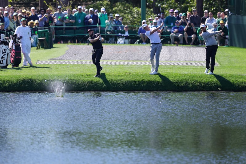 Tyrrell Hatton of England, Laurie Canter of England and Shane Lowry of Ireland skip balls across the water on the 16th hole. Photograph: Andrew Redington/Getty