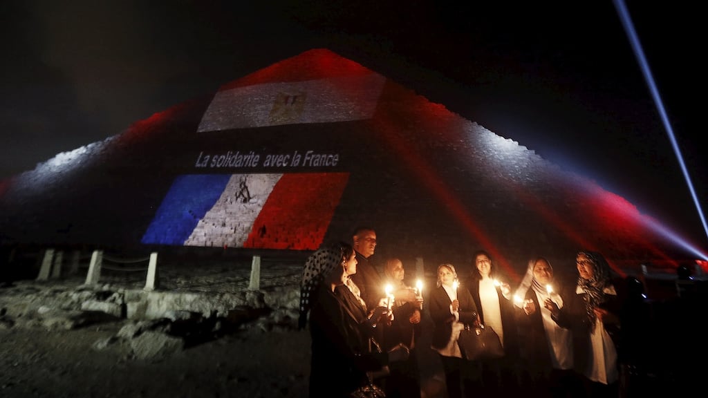 Egyptians light candles as the French and Egyptian flags and France’s national colours are projected onto one of the pyramids at Giza, outside Cairo, in tribute to the victims of the Paris attacks. The words on the pyramid read: “Solidarity with France”. Photograph: Amr Abdallah Dalsh/Reuters