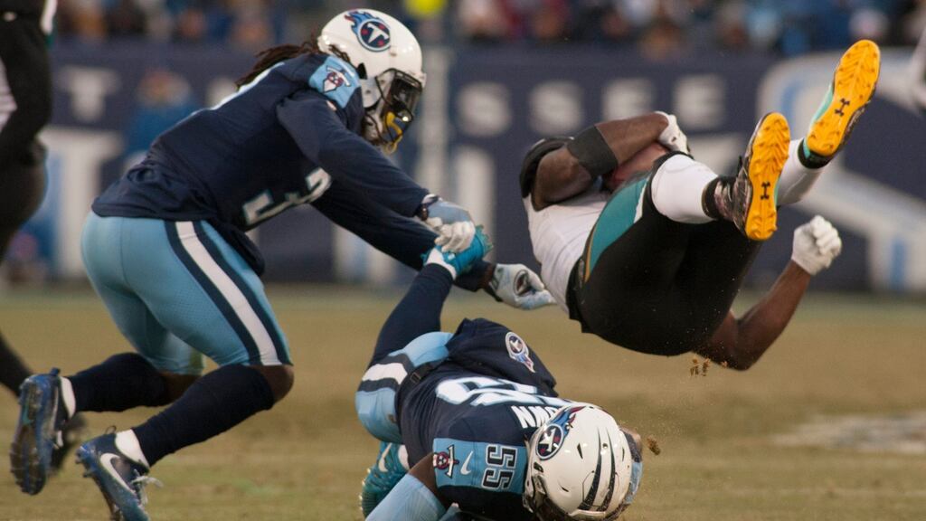 Jacksonville Jaguars running back Leonard Fournette (R) tumbles as he is tackled by Tennessee Titan defenders in the first half of their NFL game at Nissan Stadium in Nashville, Tennessee. Photo: Rick Musacchio/EPA