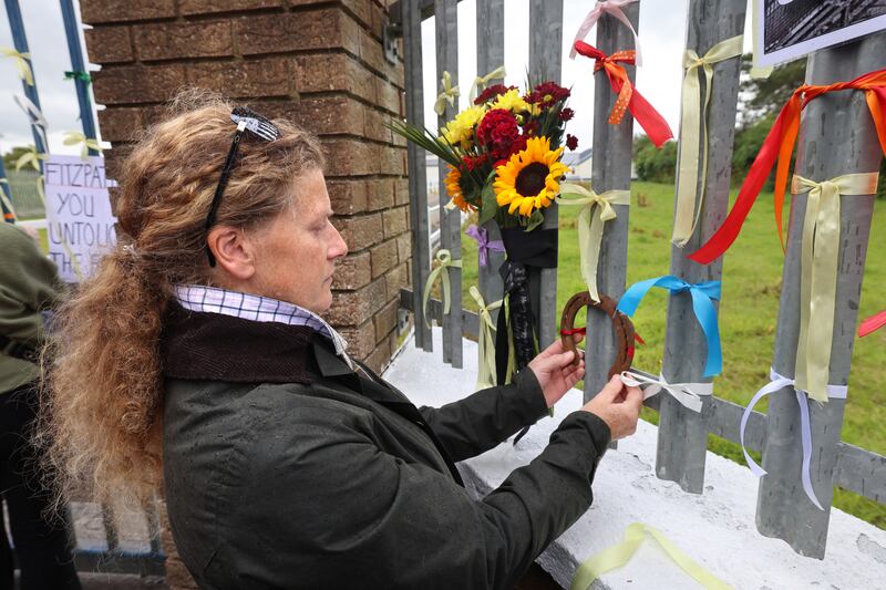 Aisling Rice from Donabate in Dublin hangs a horseshoe belonging to a horse she rescued, pictured during the protest organised by My Lovely Horse Rescue outside the Shannonside Foods plant near Straffan, Co Kildare, on Saturday. Photograph: Dara Mac Dónaill