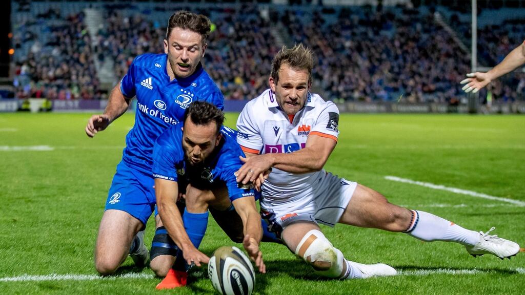 Leinster’s Jamison Gibson-Park, supported by Hugo Keenan, touches down to score a try despite the attentions of Edinburgh’s Nic Groom during the Guinness Pro 14 game at the  RDS. Photograph:  Morgan Treacy/Inpho