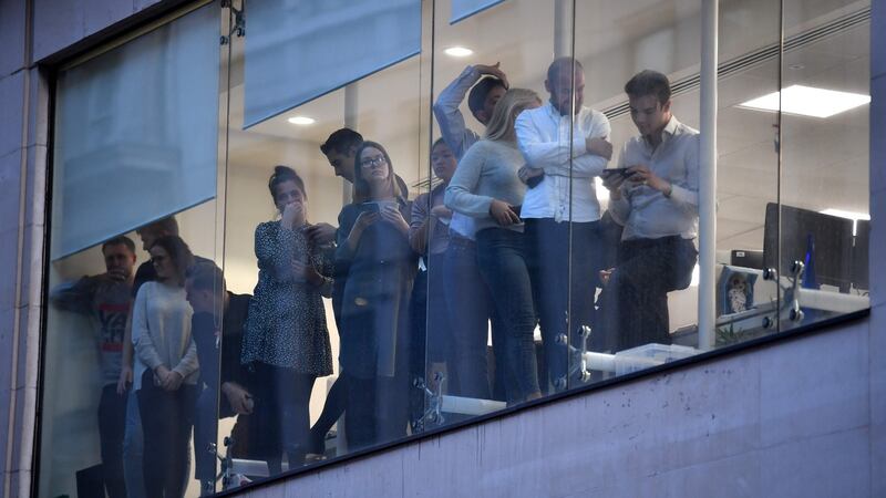 Office workers peer out of the windows of Leadenhall Market near London Bridge in central London. Photograph: Ben Stansall/AFP via Getty