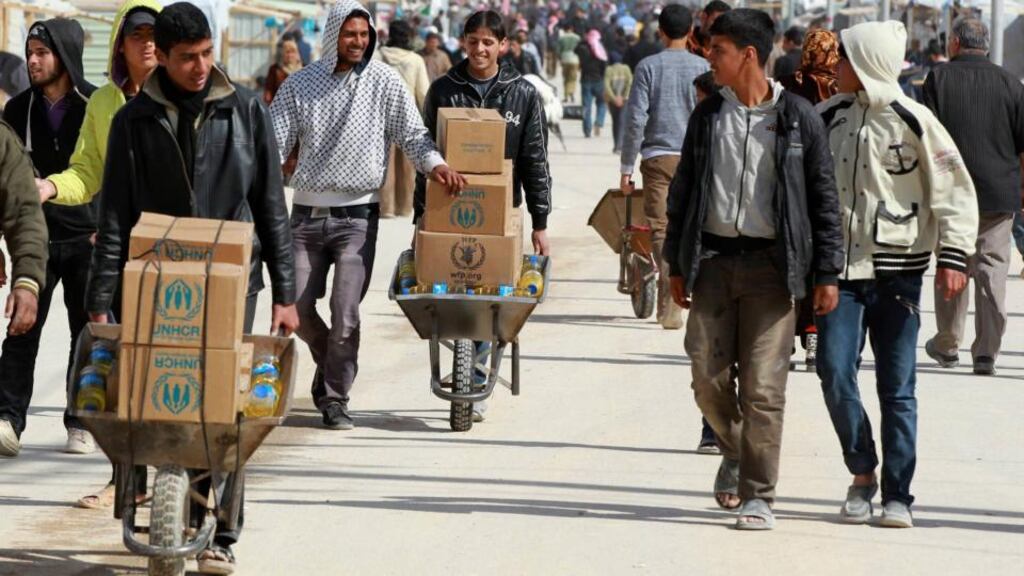 Syrian refugees collect aid and rations at the Al Zaatri refugee camp in the Jordanian city of Mafraq, near the border with Syria. Photograph: Muhammad Hamed/Reuters