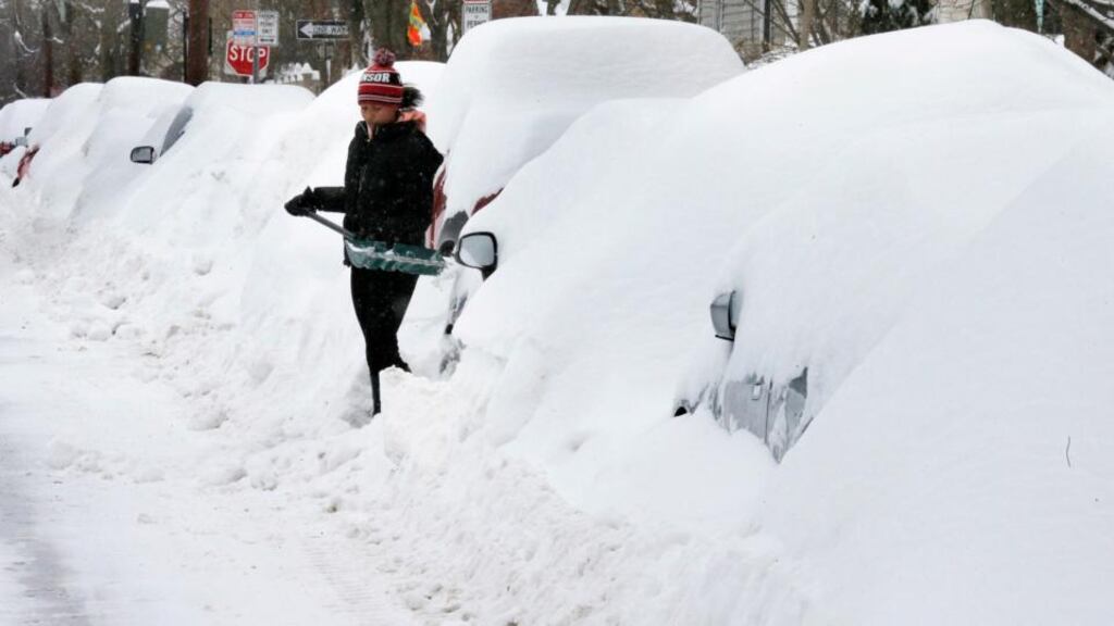 A woman shovels out her family’s car during a winter snowstorm in Cambridge, Massachusetts. Photograph: Reuters