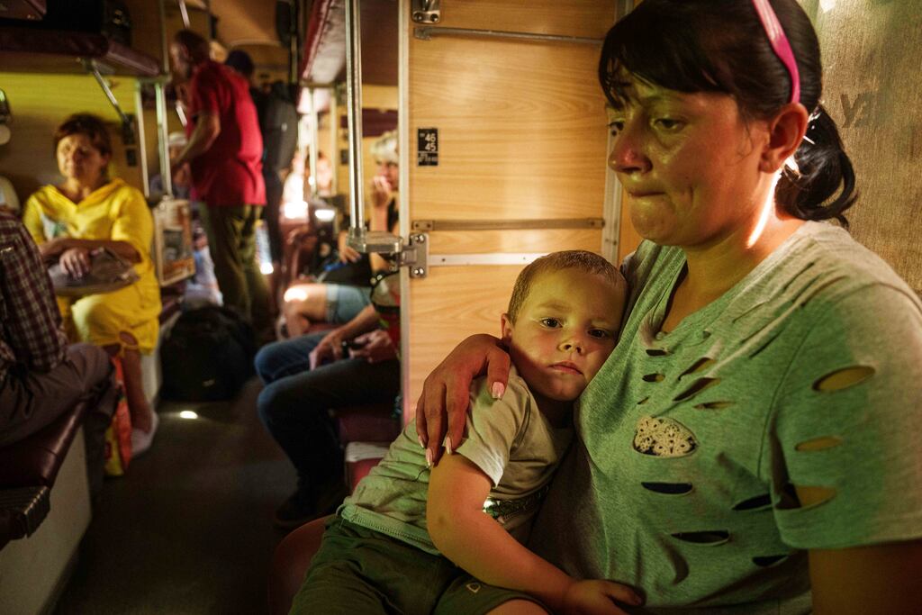 A woman named Alla hugs her son Ivan while sitting in a evacuation train in Pokrovsk, Donetsk region, Ukraine. Photograph: Evgeniy Maloletka/AP
