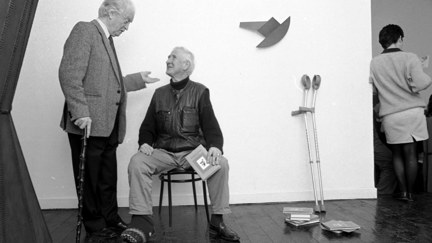 Benedict Kiely and John Montague (seated) at a reception in the Riverrun Gallery, Dublin, in 1989 to mark the publication of The Figure in the Cave and Other Essays, New Selected Poems and The Rough Field. Photograph: Matt Kavanagh