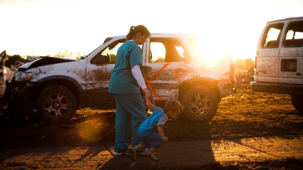 A woman and children walk by debris left after a tornado tore through the area, in Moore, Oklahoma. Photograph: Christopher Gregory/The New York Times