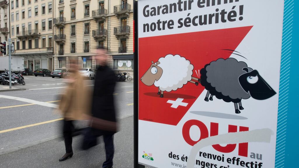 Poster campaigning for the ‘Enforcement Initiative’ seen in Geneva. Photographs: EPA/Martial Trezzini