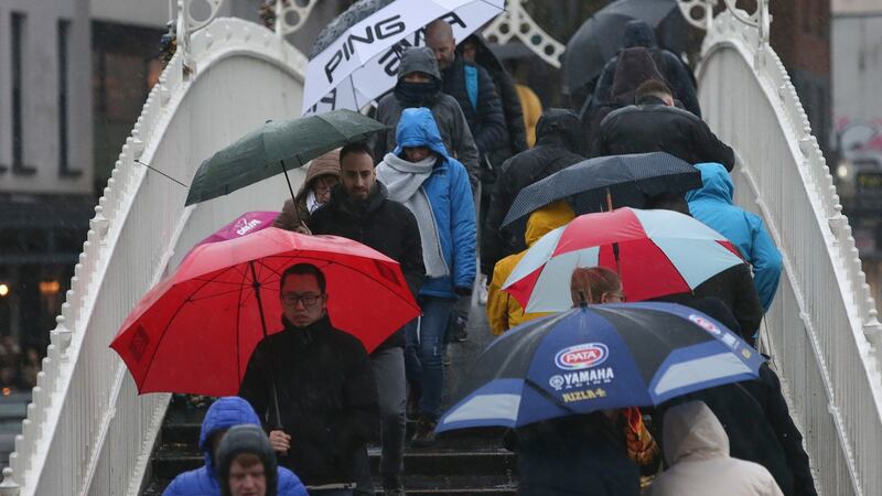Pedestrians crossing the Ha’penny Bridge in Dublin city centre as heavy rain falls during Storm Dennis on Saturday. Photograph: Damien Eagers/The Irish Times.