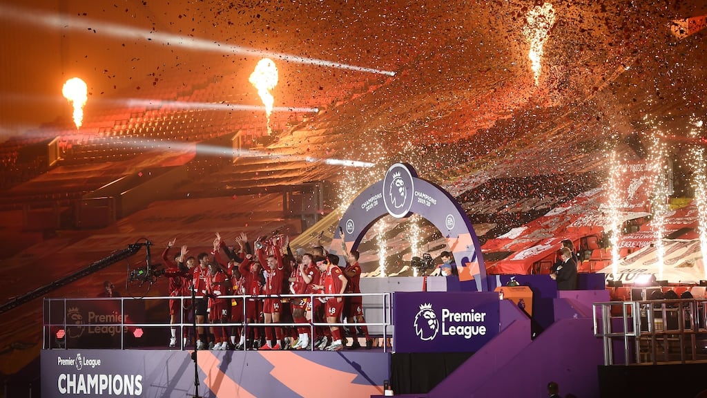 Jordan Henderson of Liverpool holds the Premier League trophy aloft as they celebrate winning the title at an empty Anfield after the victory over Chelsea in July. Photograph: Laurence Griffiths/Getty Images