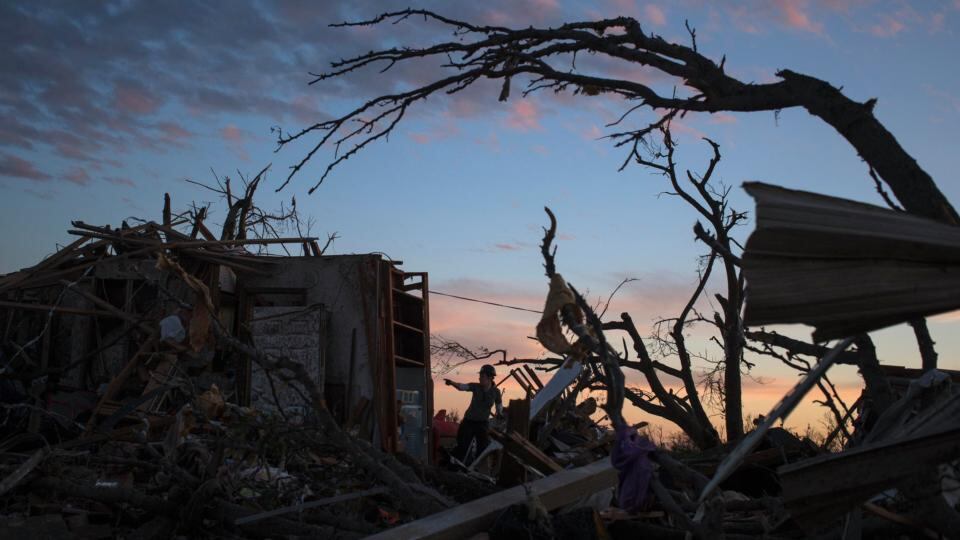 A woman searches for possessions at sunset after the suburb of Moore, Oklahoma was left devastated. Rescuers went building to building in search of victims and survivors picked through the rubble of their shattered homes yesterday. Photograph: Adrees Latif/Reuters