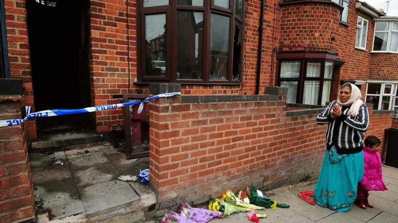 A local resident says a prayer outside the scene of the fatal house fire in Wood Hill, Leicester last year. Photograph: PA