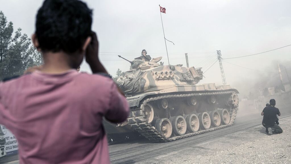 Turkish army tanks and armoured personnel carriers moving toward the Syrian border, in Karkamis, Turkey. Photograph: Halit Onur Sandal/AP Photo